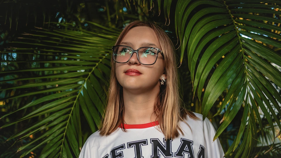 Portrait of a woman wearing glasses before editing, with reflections on the lenses